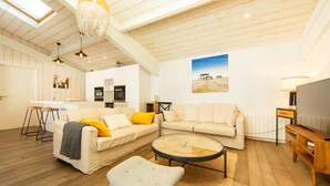 A spacious living room with a high ceiling, a round coffee table, and a sofa set.