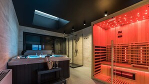 A modern bathroom with a sauna, a glass-enclosed shower area, and a bar with a view of the outdoors.