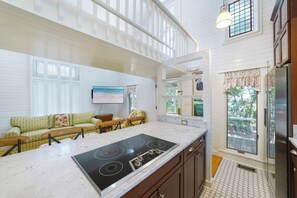 A kitchen with a central island, wooden cabinets, and a large window. - Just 1 Minute to Beach Access in Seaside, Bonus Living Area + 2 Adult Bikes! (Santa Rosa Beach)