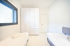 A bedroom with a large wardrobe, a bed, and a window.
