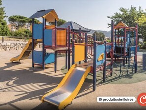 Children can play and explore in this outdoor play area with a slide, climbing frames, and a shelter.