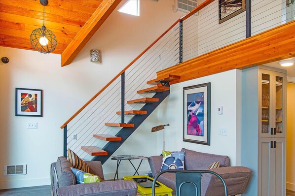 Una escalera con barandas de madera y una lámpara moderna.