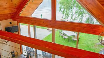 A wooden interior with large windows overlooking a grassy outdoor area.