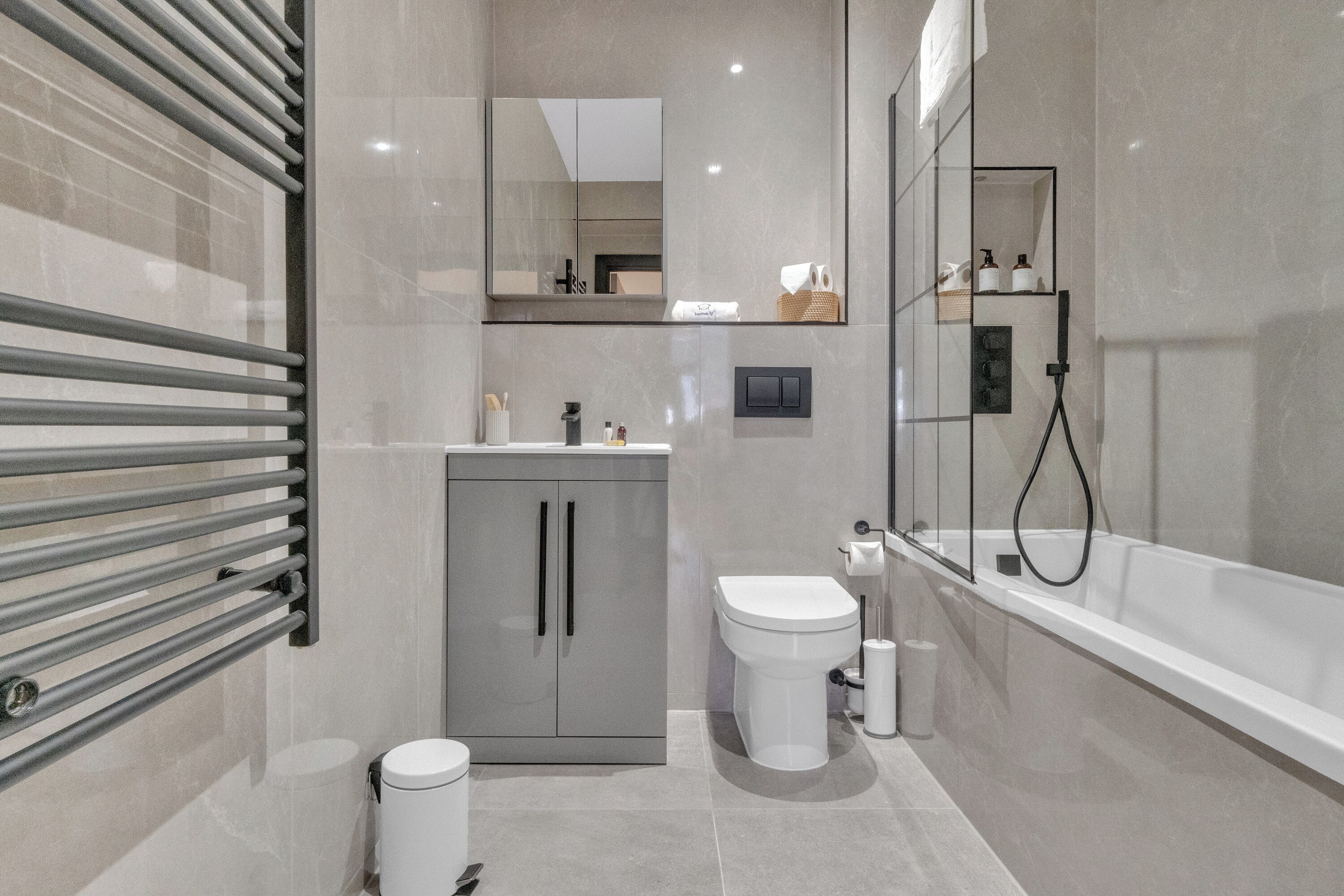 A modern bathroom with a toilet, sink, and bathtub.
