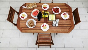 A wooden dining table with plates of food, including tomatoes, watermelon, and nuts. - Lentisco - Residenza Arcangela con Piscine nel Salento (Corsano)