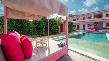 Una piscina al aire libre, camas de piscina gratis, sombrillas