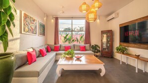 A modern living room with a sectional sofa, a coffee table, and artwork on the walls. - PinkPrivate Balangan - for Cool Adults Only (Jimbaran)