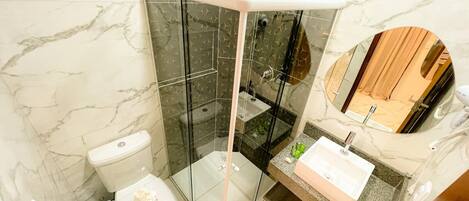 A modern bathroom with a glass-enclosed shower, a toilet, and a sink with a mirror.