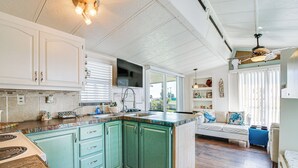 Une cuisine avec des armoires de couleur turquoise, une cuisinière et un évier.