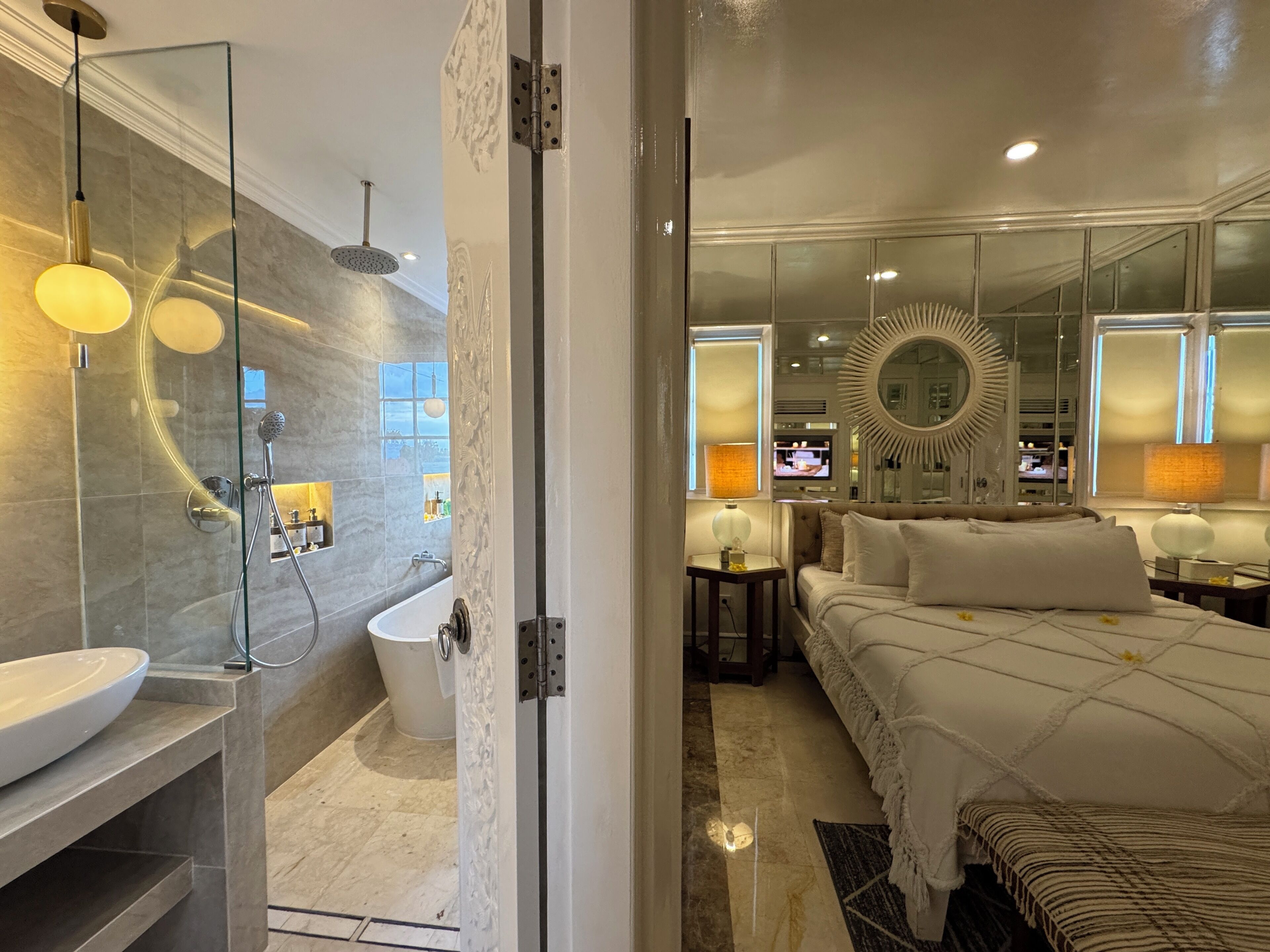 A modern bathroom with a glass-enclosed shower, a standalone bathtub, and a large mirror.