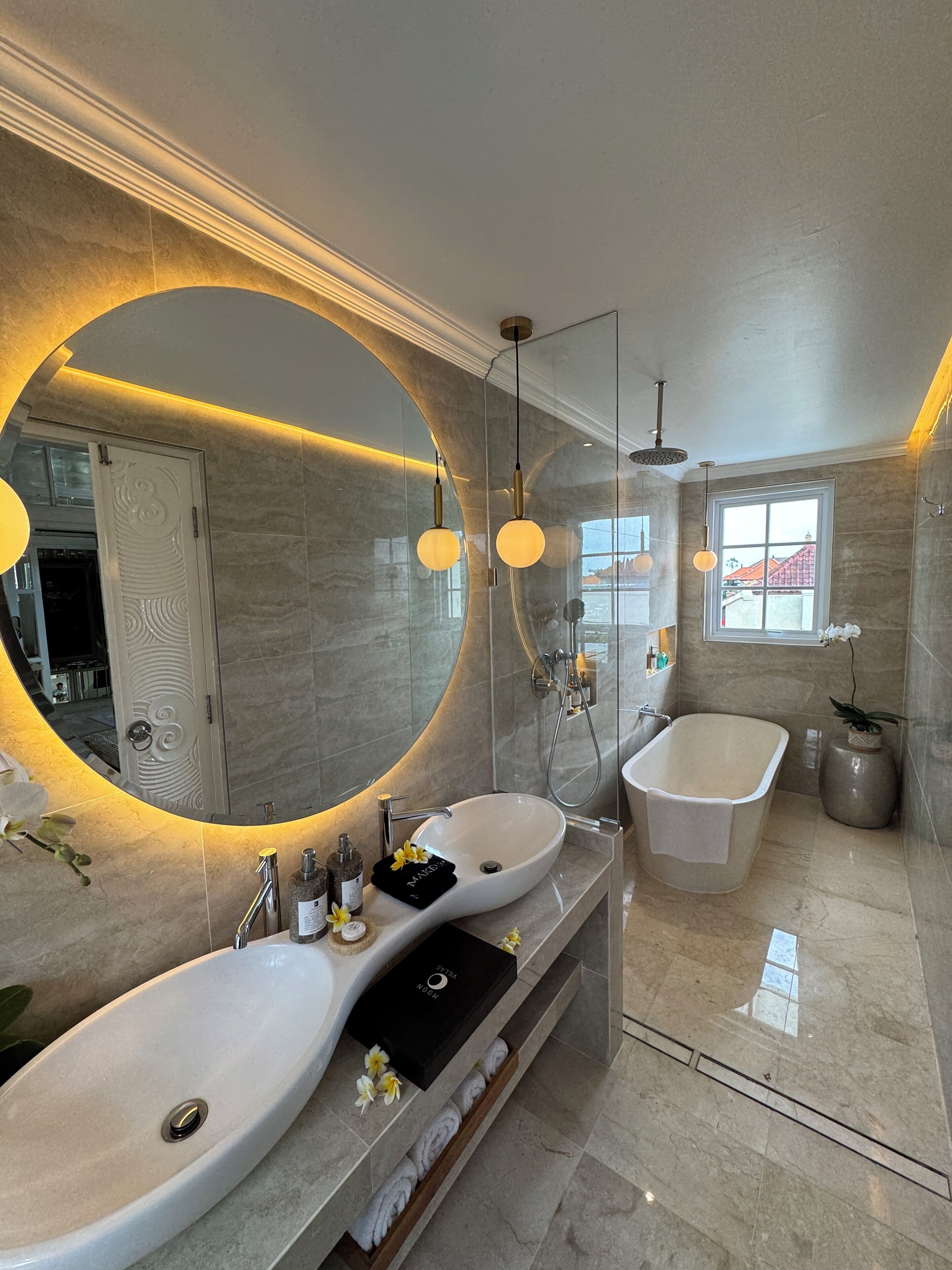 Un baño moderno con dos lavamanos, un espejo grande y una bañera.