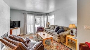 Un salon avec un canapé, un fauteuil et un téléviseur.