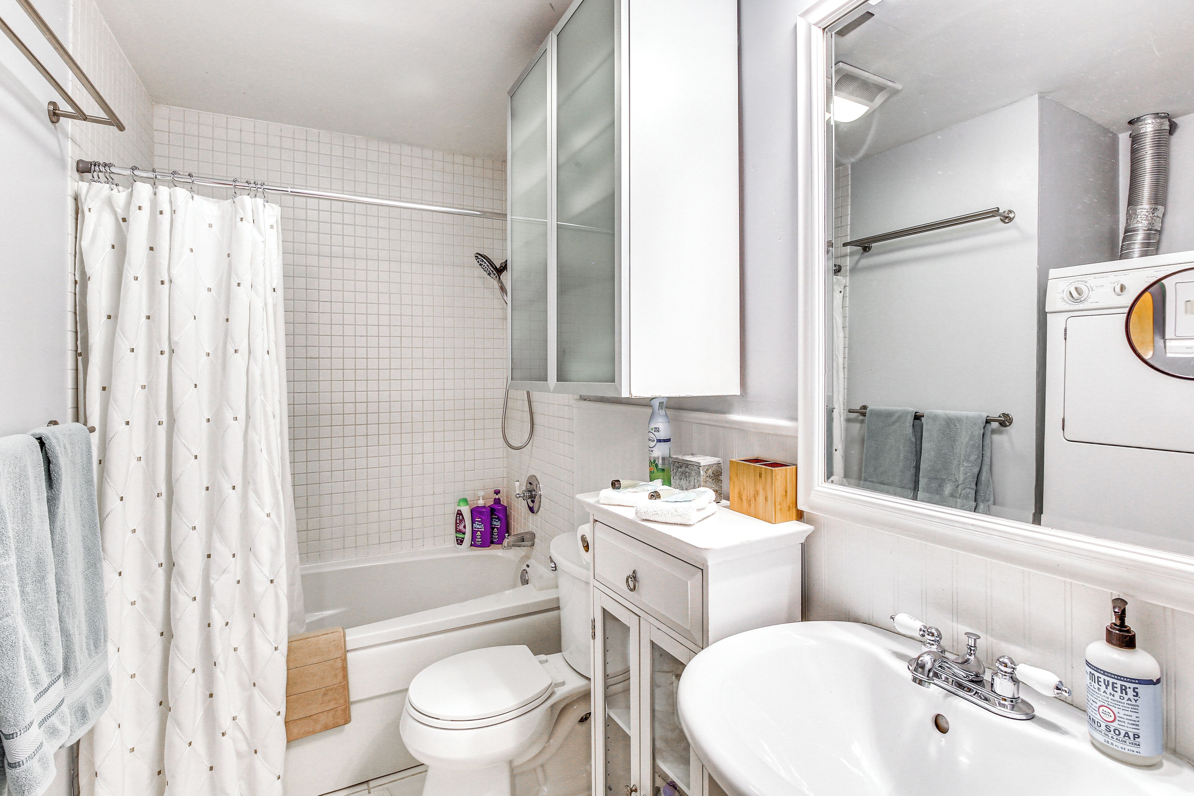 Un baño con bañera, inodoro, lavabo y espejo.