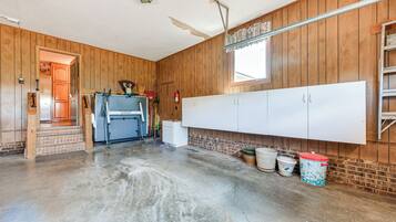 A spacious room with wooden walls, a large white cabinet, and a concrete floor.