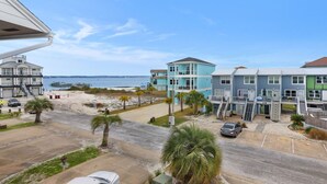 A coastal hotel with multiple buildings, a beach view, and a parking area with cars. - Sugar Dunes 124 | 🌅 Sound Views | 🌴 Steps to Beach | 🍽 Walk to Dining (Navarre Beach)