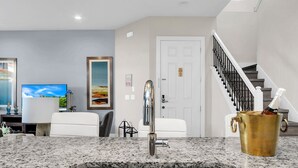 A modern kitchen with granite countertops, a stainless steel sink, and pendant lighting. - 5 BR 6 BA Villa 5min Disneyworld Hot Tub BBQ (Kissimmee)