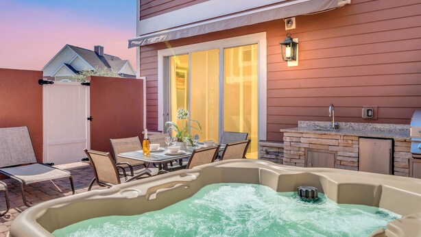 A backyard with a hot tub, patio furniture, and a stone fireplace. - 5 BR 6 BA Villa 5min Disneyworld Hot Tub BBQ (Kissimmee)