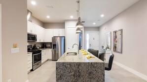 A modern kitchen with granite countertops, stainless steel appliances, and a central island. - 4 BR 4 BA Villa 5min Disneyworld 1804ft BBQ (Kissimmee)
