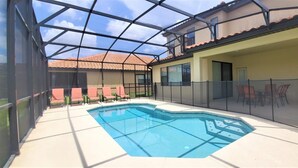A covered swimming pool with a glass ceiling, surrounded by lounge chairs and a patio area. - Grand Superior 4BD Pool Home at Disney Universal (Davenport)