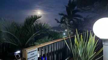 A nighttime view of a pool area with a sign indicating it is for residents only.