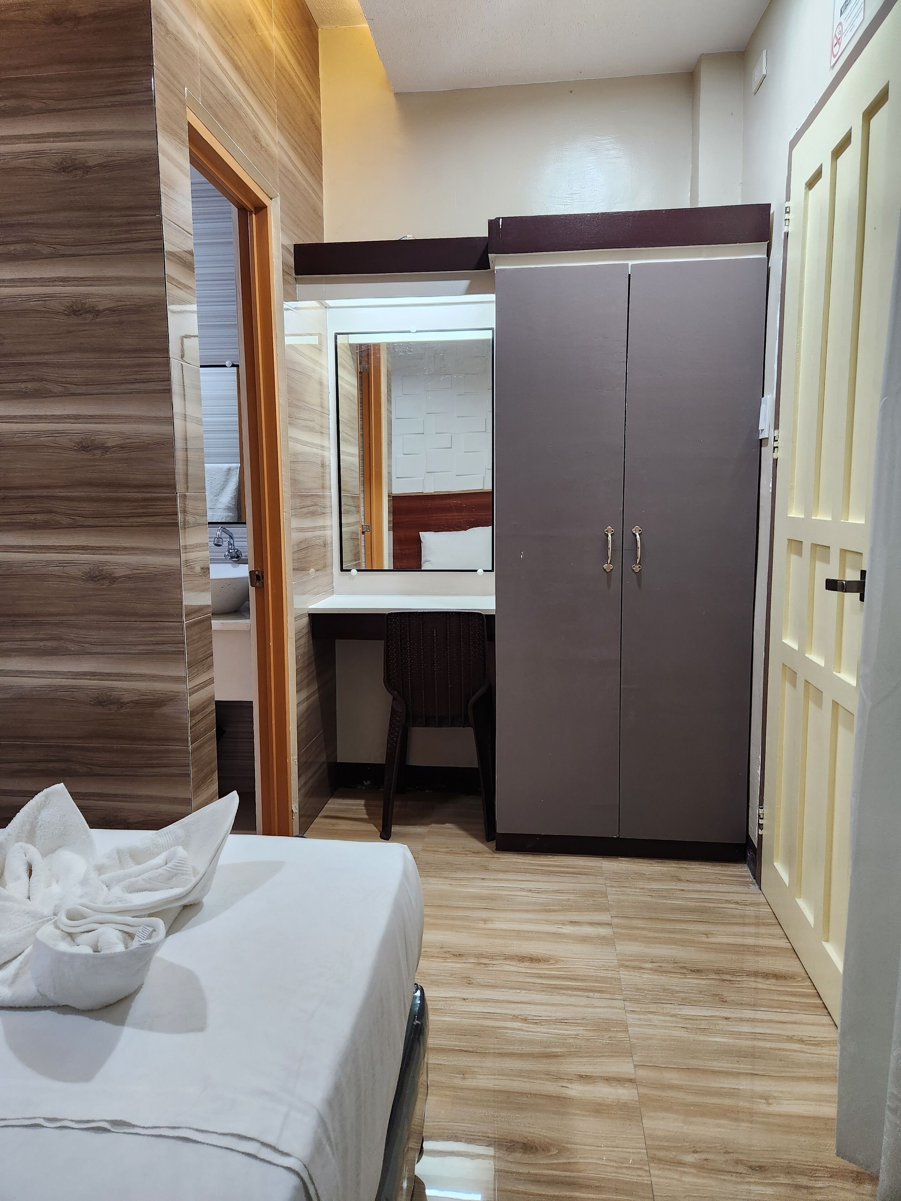 Una camera d'albergo con un letto, una scrivania e un armadio.