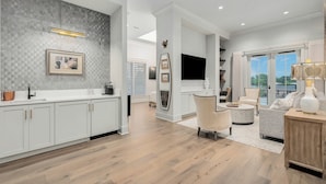 A modern kitchen with white cabinets, a patterned backsplash, and a large window.