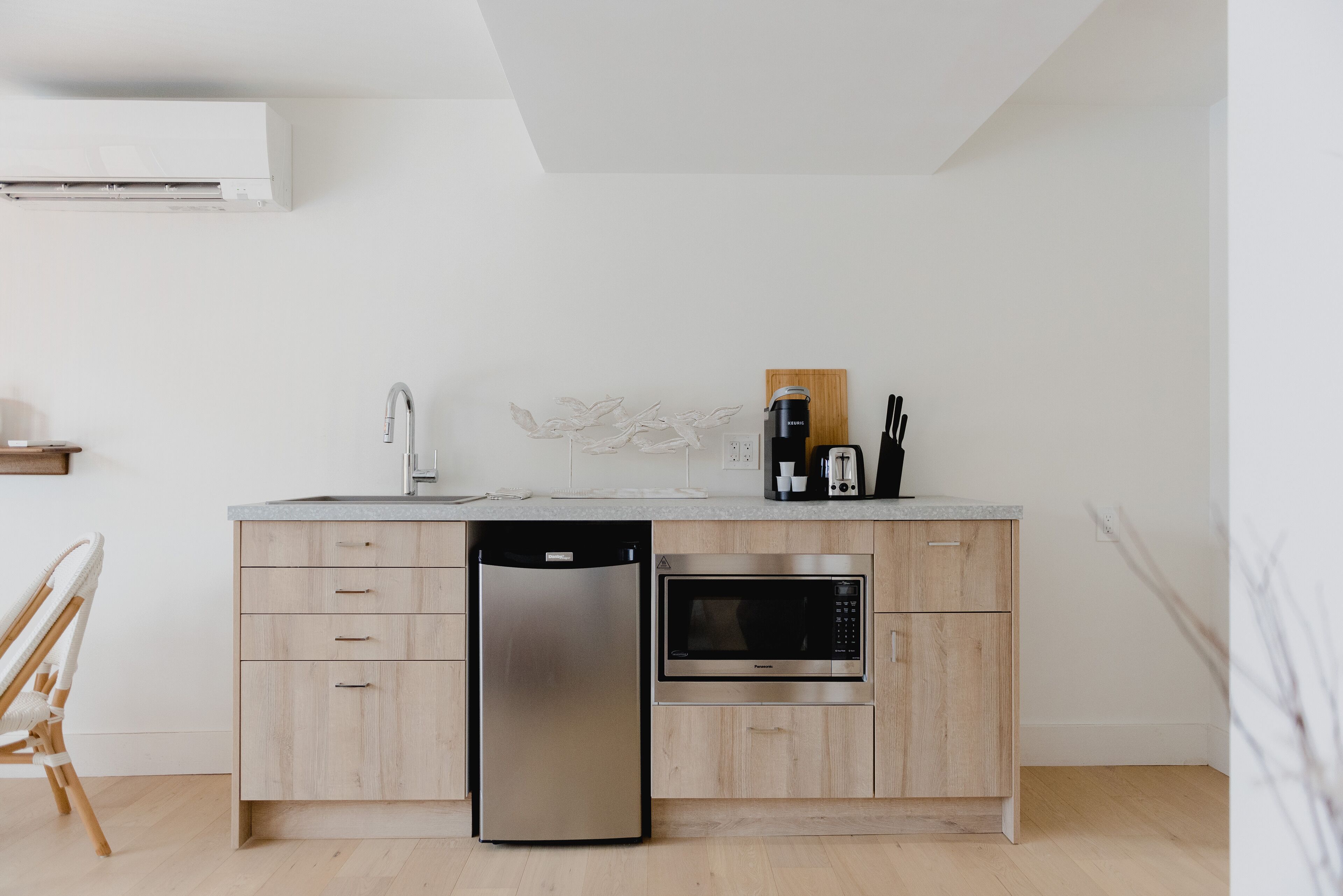 A modern kitchen with a dishwasher, microwave, and wooden cabinets.