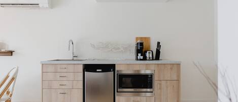 A modern kitchen with a dishwasher, microwave, and wooden cabinets.
