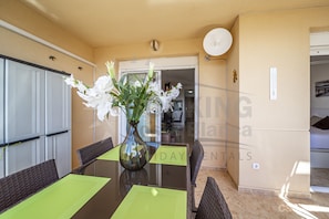 Dine in style with a glass-top table and comfortable wicker chairs.
