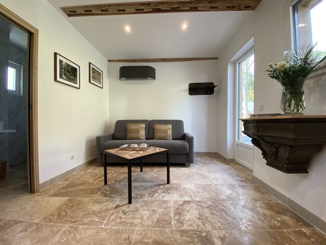 Un salon avec un canapé, une table basse et une cheminée.