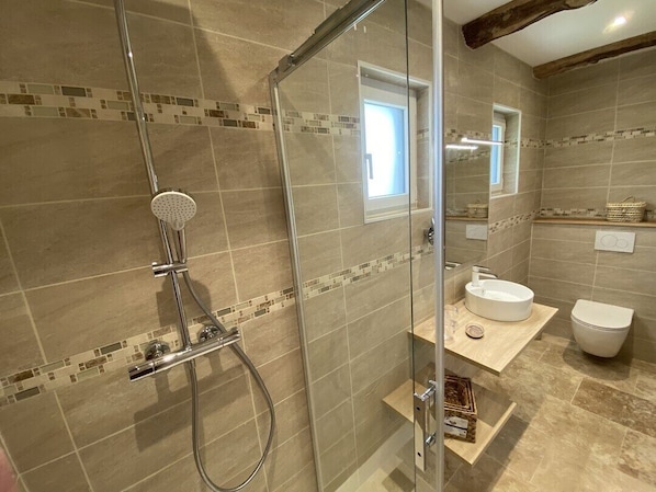 A modern bathroom with a glass-enclosed shower, a white sink, and a toilet. - Le Domaine d'Angerville (Angerville)