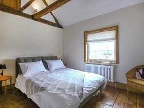 A bedroom with a bed, a window, a radiator, a lamp, and a chair. - 2 bedroom accommodation in Ludlow (Ludlow)
