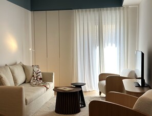 A modern living room with a sofa, armchair, and a round table. - Aionion Residences by K&K - Vassili Luxury Residence (Athina)