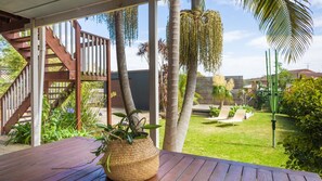 A wooden deck with a woven basket, palm trees, and a grassy area with lounge chairs. - 30 Tatiara Street,  Dalmeny (Dalmeny)