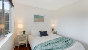 A bedroom with a bed, two bedside tables, a window, and a painting on the wall. - 30 Tatiara Street, Dalmeny (Dalmeny)