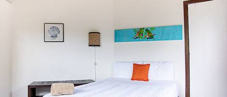 Un dormitorio con cama, escritorio y una obra de arte en la pared.