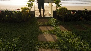A person holding a surfboard at the beach. - Hotel Perla de la Playa (Tamarindo)