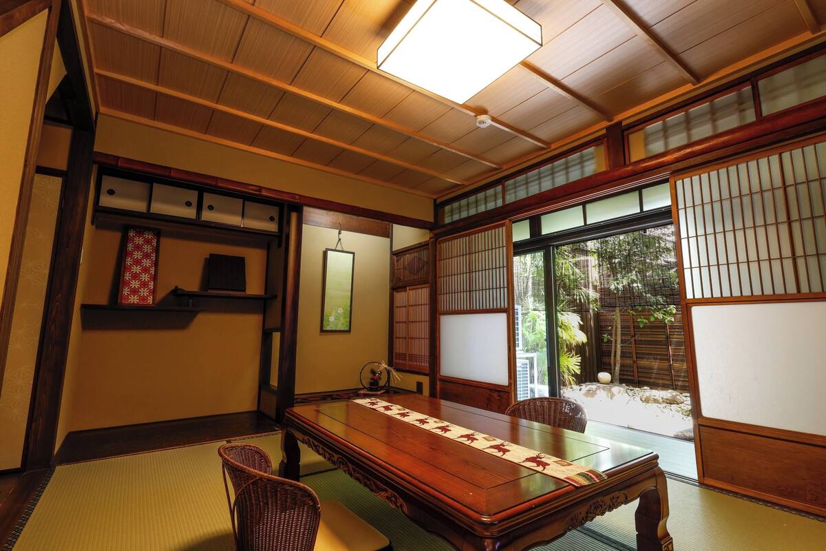 A traditional Japanese room with tatami flooring, a low wooden table, and sliding doors.