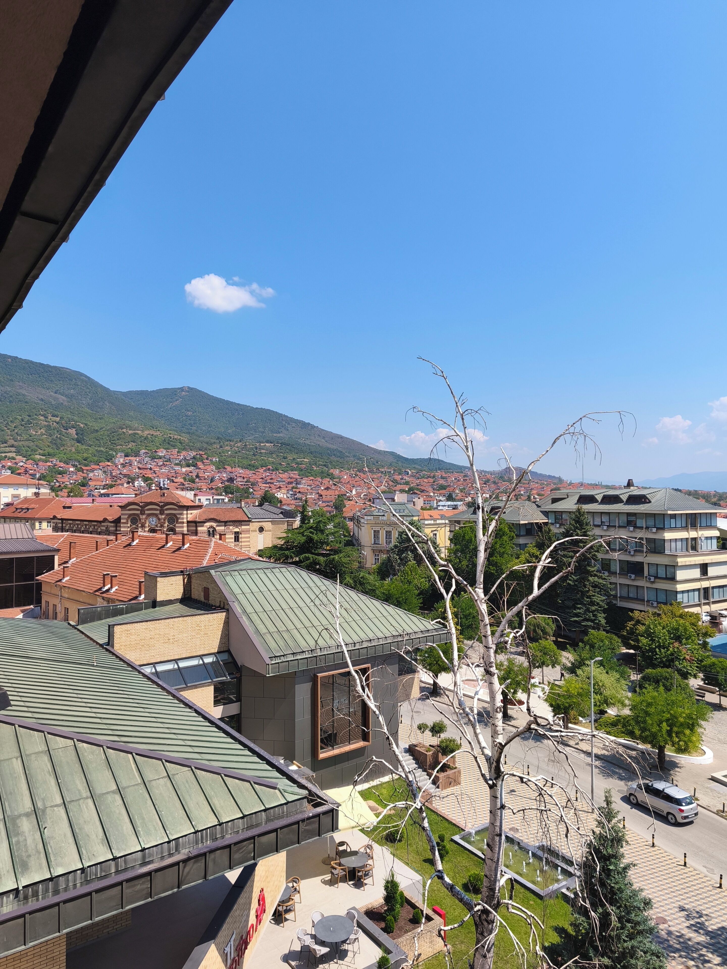 Vista di una città con edifici e una montagna sullo sfondo.