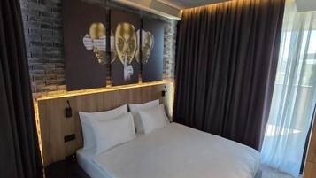 Un dormitorio moderno con una cama grande, una pared de ladrillo decorativa y una unidad de aire acondicionado instalada en el techo.