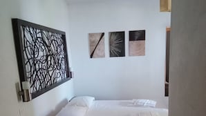 A bedroom with a bed, a cabinet, and wall art. - Accogliente Camera con Grande Terrazzo. Animali Domestici Ammessi (Vieste)