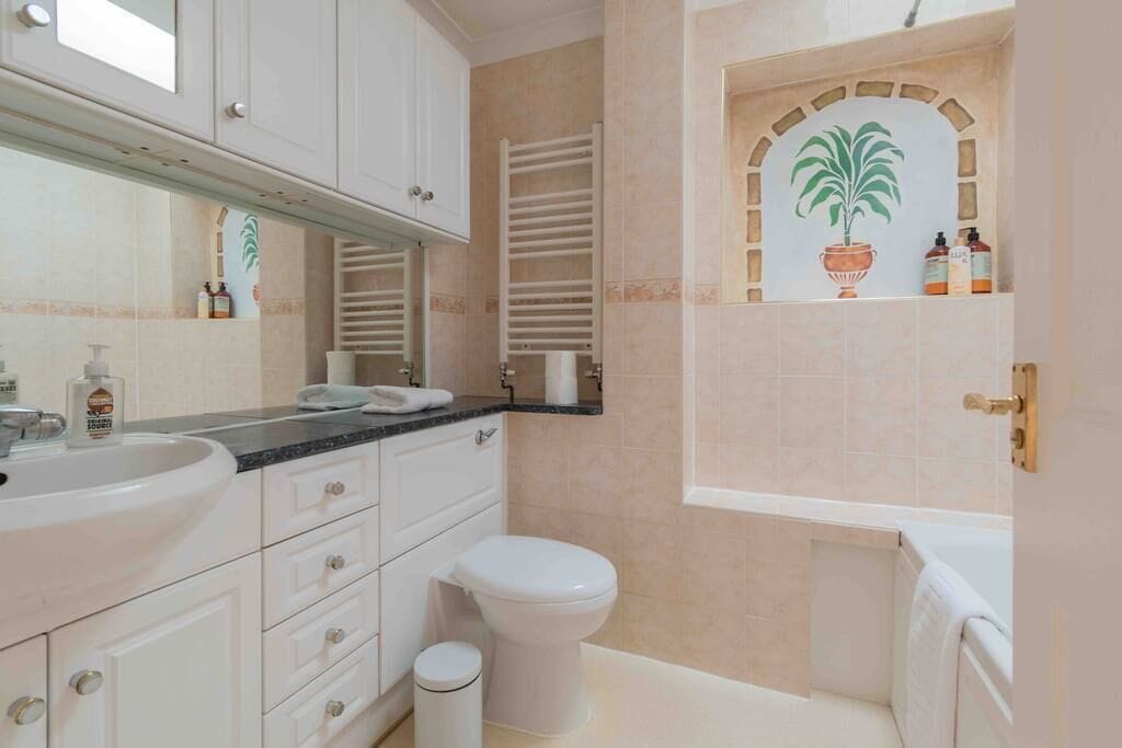 A bathroom with a sink, toilet, and a towel rack.
