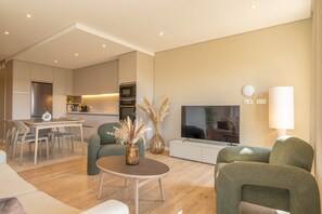 Ein modernes Wohnzimmer mit Essbereich, Küche und Flachbildfernseher.