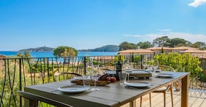 Taula preparada per a dinar amb vista al mar i a les muntanyes.