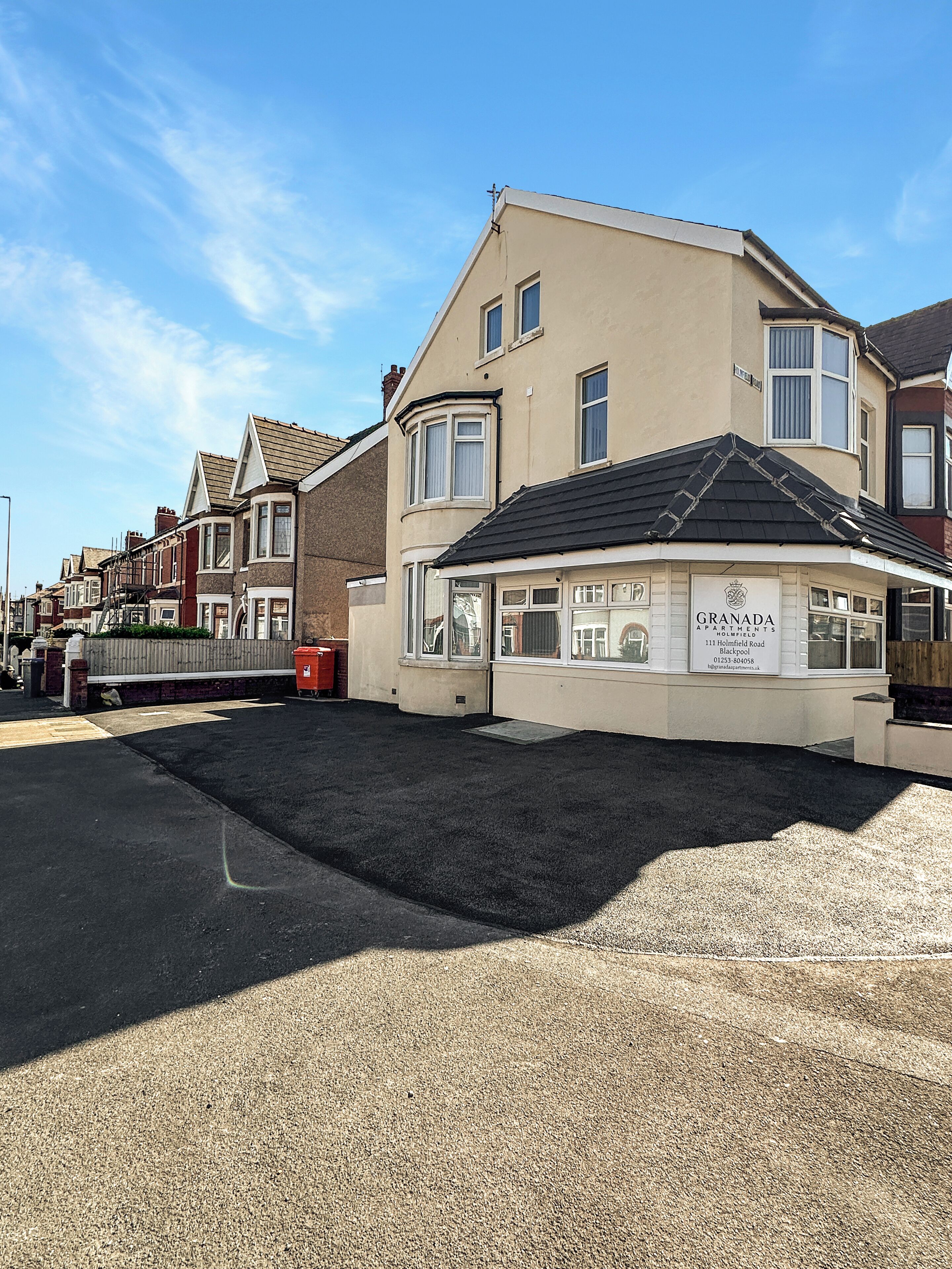 En bygning med et skilt, der viser "GRANADA APARTMENTS 111 Holmfield Road Blackpool".