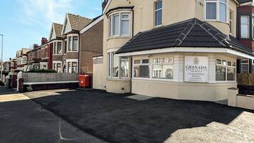 En bygning med et skilt, der viser "GRANADA APARTMENTS 111 Holmfield Road Blackpool".