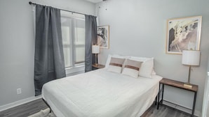 A bedroom with a bed, two bedside tables with lamps, a ceiling fan, and two framed pictures on the wall. - Wonderful 3 BR 2 BA Near Downtown (San Antonio)