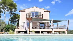 A two-story building with a balcony, a pool, and outdoor seating. - Alexandre Chambre D'hôte (LA LONDE LES MAURES)