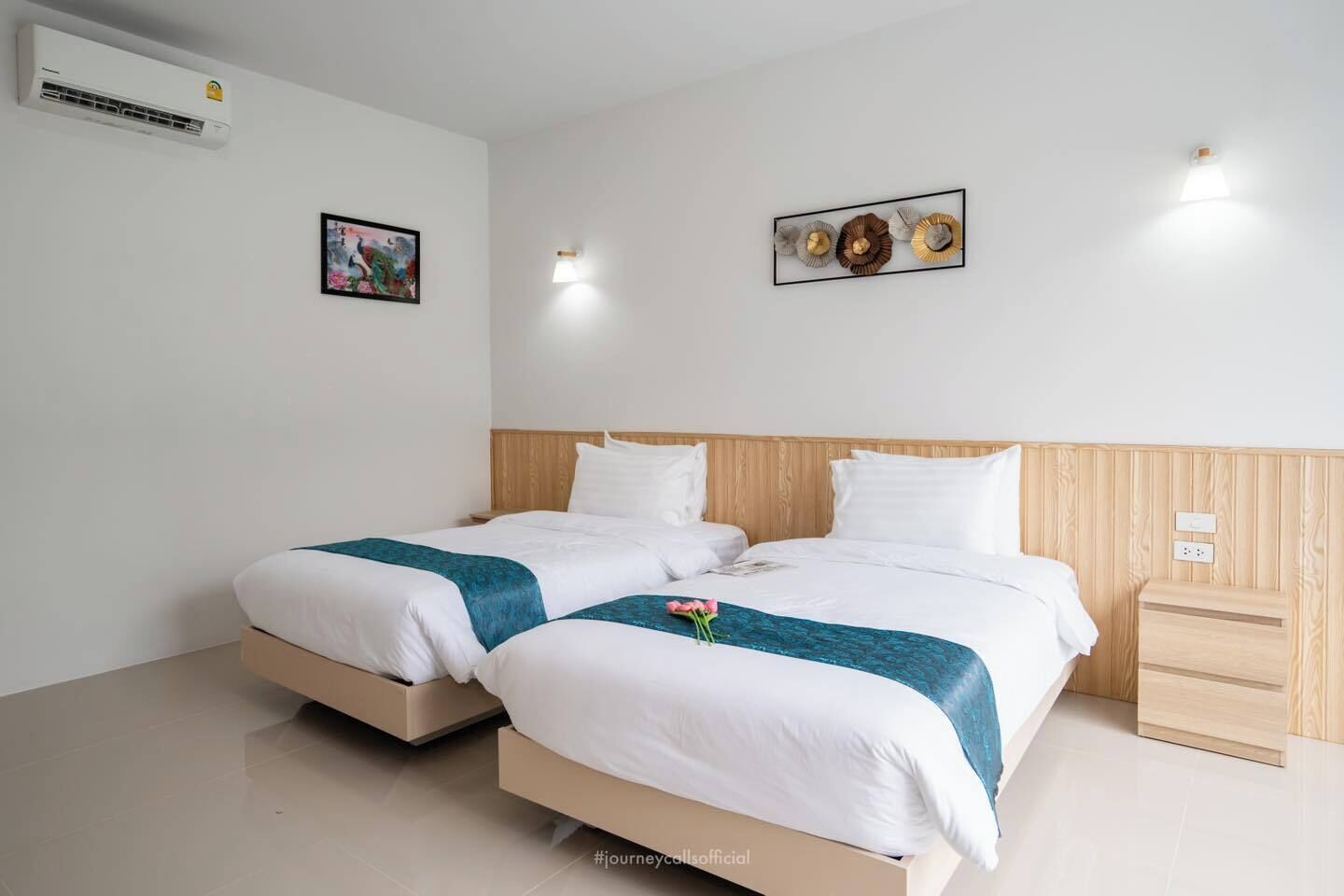 Una cama doble con cabecera de madera, dos mesitas de noche y un aire acondicionado instalado en la pared.