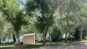Zona de grava amb una petita caseta i una bosc proper.